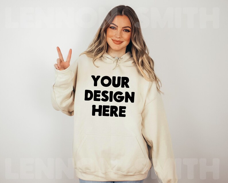 Może przedstawiać: Kremowa bluza z kapturem z czarnym nadrukiem "YOUR DESIGN HERE".