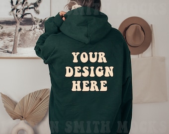 May include: A dark green hooded sweatshirt with the text "YOUR DESIGN HERE" printed in a light cream color on the front.