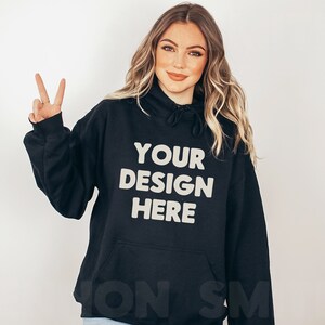 Może przedstawiać: Czarna bluza z kapturem z napisem "YOUR DESIGN HERE" w jasnobeżowym kolorze.