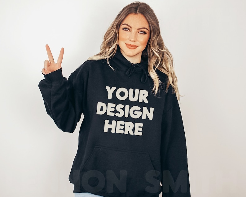 Może przedstawiać: Czarna bluza z kapturem z napisem "YOUR DESIGN HERE" w jasnobeżowym kolorze.