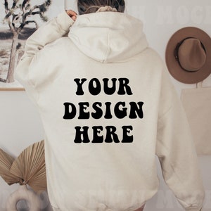 Peut inclure: Un sweat à capuche crème avec une inscription en noir de style rétro "YOUR DESIGN HERE" au dos.