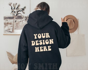 May include: Black hooded sweatshirt with the text "YOUR DESIGN HERE" in a retro font on the back.