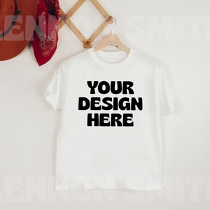 May include: White t-shirt with the text "YOUR DESIGN HERE" printed in black on the front.