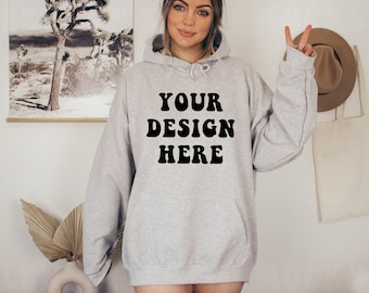 May include: A gray hooded sweatshirt with the text "YOUR DESIGN HERE" printed in black on the front.