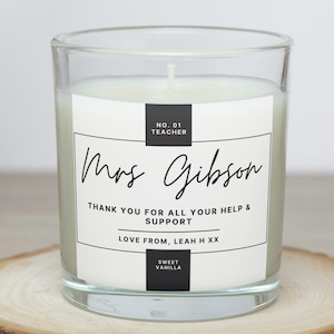 May include: A clear glass candle with a white label featuring the text "Mrs. Gibson" and "Thank you for all your help & support." The candle is scented with sweet vanilla and is a teacher appreciation gift.