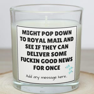 May include: A clear glass candle holder with a white candle inside. The candle has a white label with black text that reads "MIGHT POP DOWN TO ROYAL MAIL AND SEE IF THEY CAN DELIVER SOME FUCKIN GOOD NEWS FOR ONCE." The text "HA HA HA" is also on the label.