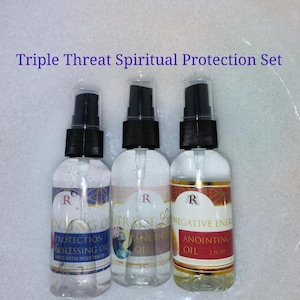 May include: Triple Threat Spiritual Protection Set with three clear glass bottles with black spray tops. The bottles contain a clear liquid and have labels with gold lettering. The labels read "Protection & Blessing Oil", "Anointing Oil", and "Anointing Oil".