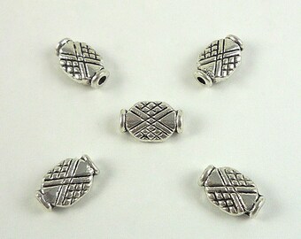 May include: Five silver oval-shaped beads with a geometric design. The beads have a textured surface and are designed for use in jewelry making.
