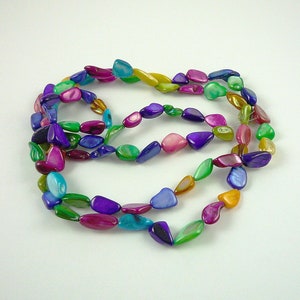 May include: A multi-colored necklace made of iridescent shell beads. The beads are shaped like teardrops and are strung on a clear thread. The necklace is approximately 30 inches long.