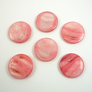 May include: Six round, pink, mother-of-pearl shell buttons with a white iridescent sheen.