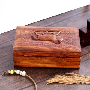 May include: A wooden box with a carved horse design on the lid. The box is made of dark brown wood and has a hinged lid.