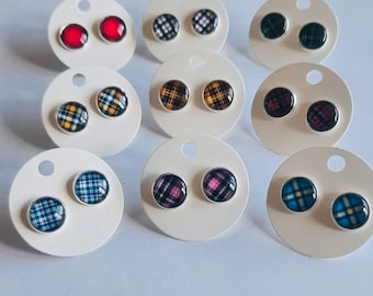 May include: Assortment of plaid and solid color stud earrings displayed on white circular cards. The earrings are silver-toned with a variety of colors including red, blue, green, yellow, and pink.