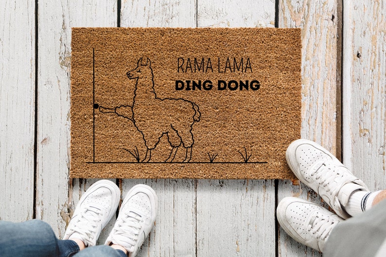 May include: A brown doormat with the text "Rama Lama Ding Dong" and a black line drawing of a llama with its tongue sticking out.