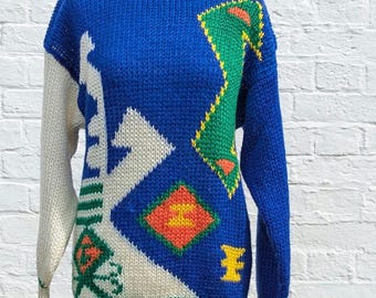 May include: A blue, white, green, yellow and orange knitted jumper with a geometric pattern.