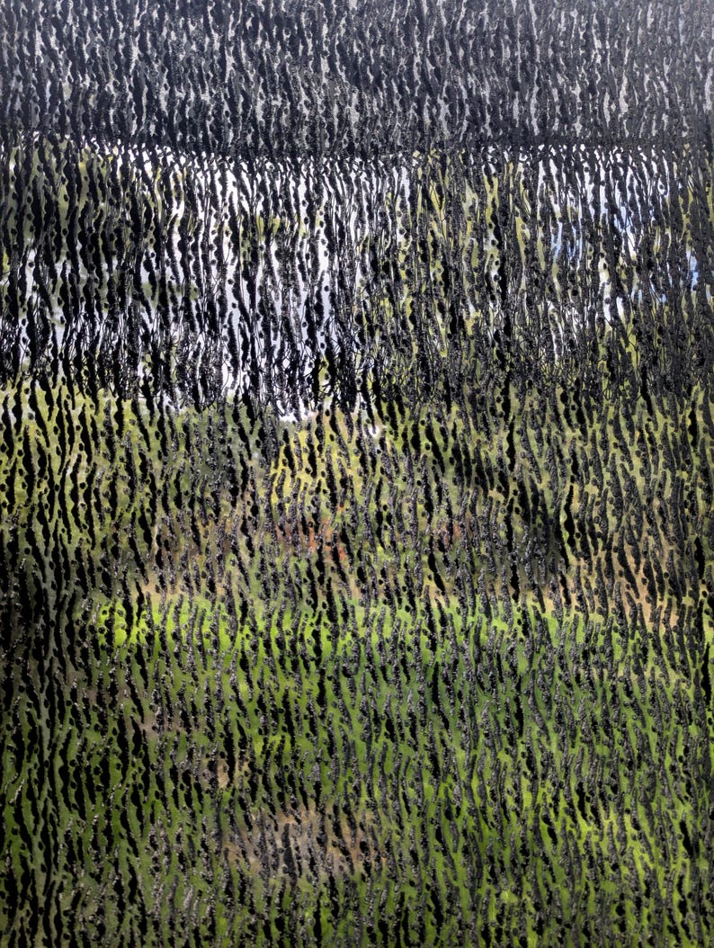 May include: A black mesh fabric featuring a dense, vertical, and textured pattern of raised, fuzzy, dark fibers. The material is semi-transparent, allowing a view of a green and light-colored background through the gaps in the weave.