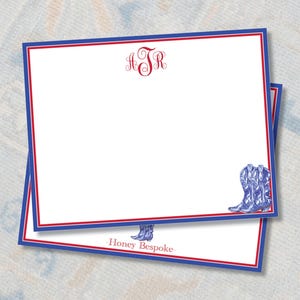 May include: A stack of white note cards with a blue and red border. The top card has a red monogram "JSR" and the bottom card has the text "Honey Bespoke" and a blue and white illustration of cowboy boots.