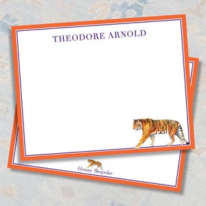 May include: Two white notecards with orange and purple borders. The name "THEODORE ARNOLD" is printed at the top. A watercolor tiger illustration is at the bottom. The words "Honey Bespoke" are printed at the bottom.