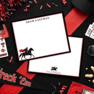 May include: Two rectangular white stationery sheets with a black and red border. The top sheet features the name ADAM EASTMAN in black text and a graphic of a rider on a black horse with a red cape. The bottom sheet displays the same rider graphic.