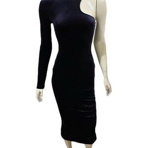 May include: A black velvet midi dress with a one-shoulder design and a cut-out detail on the shoulder.