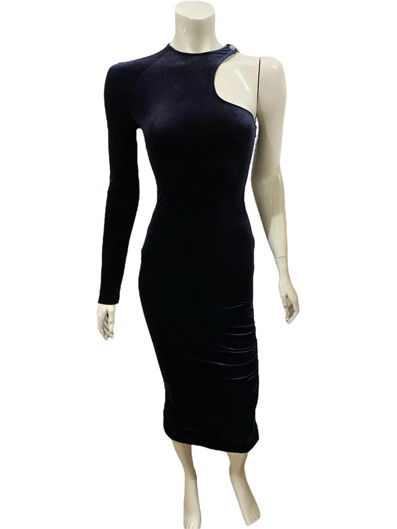 May include: A black velvet midi dress with a one-shoulder design and a cut-out detail on the shoulder.