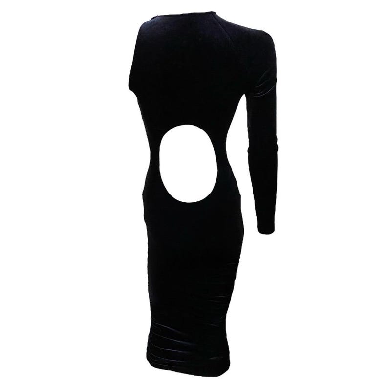May include: A black velvet midi dress with a cut-out detail on the back. The dress has long sleeves and a fitted silhouette.