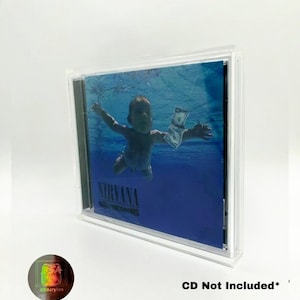 May include: A clear acrylic CD case displaying the album cover of Nirvana's "Nevermind". The album art features a baby swimming underwater reaching for a dollar bill. The text "Nirvana Nevermind" is visible on the album cover.