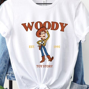 a white woody t - shirt hanging on a clothes rack