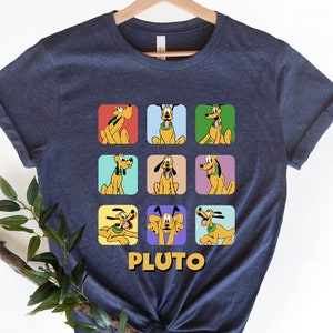 May include: A navy blue t-shirt with a graphic of Pluto in nine different poses. Each pose is in a colorful square. The text "PLUTO" is printed below the squares.