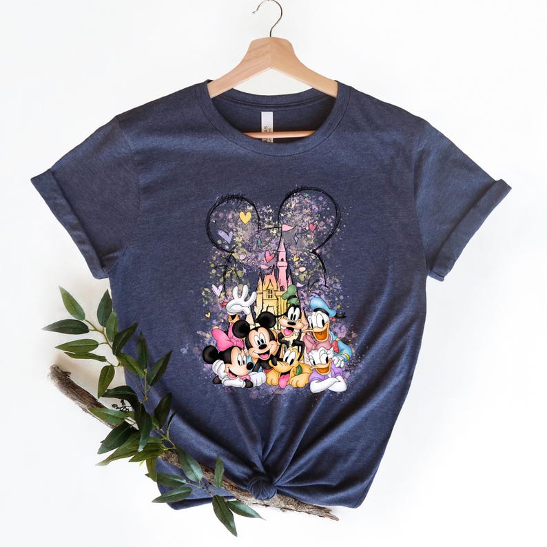 May include: A navy blue t-shirt with a graphic print of Mickey Mouse and friends in front of Cinderella's Castle. The graphic is surrounded by pink, purple, and blue hearts and stars.