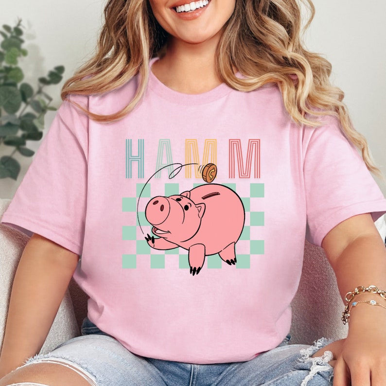a woman wearing a pink shirt with a pig on it