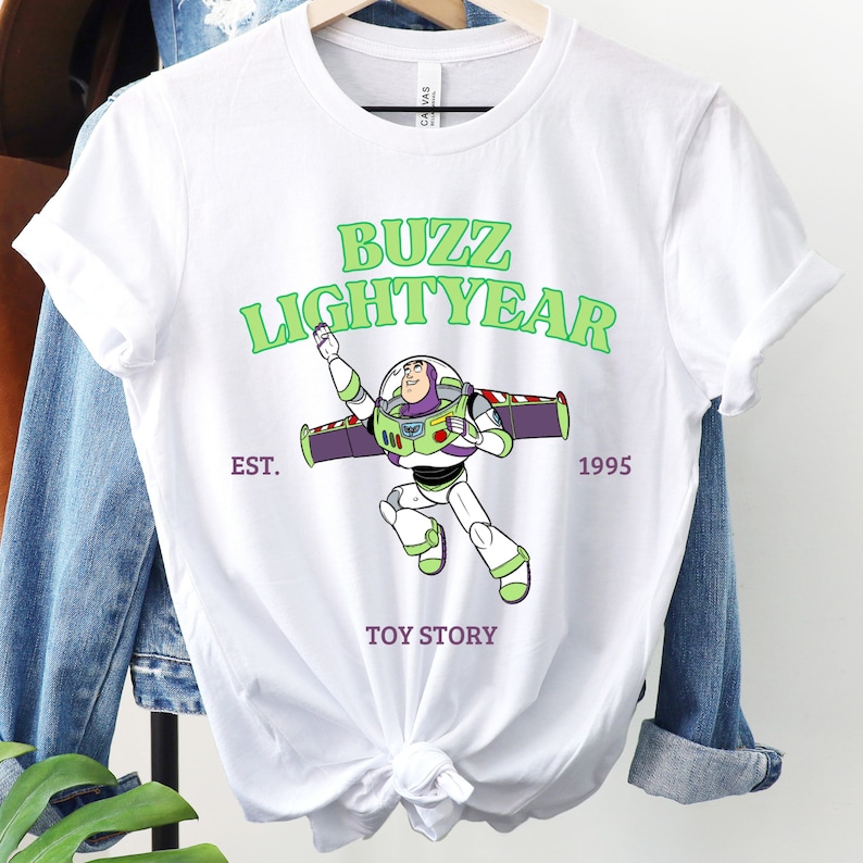 a buzz lightyear t - shirt hanging on a clothes rack