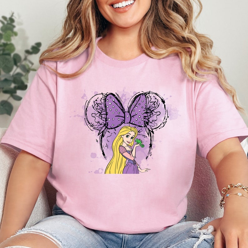 a woman wearing a pink shirt with a cartoon character on it