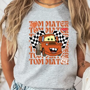 a woman wearing a gray shirt with a cartoon character on it