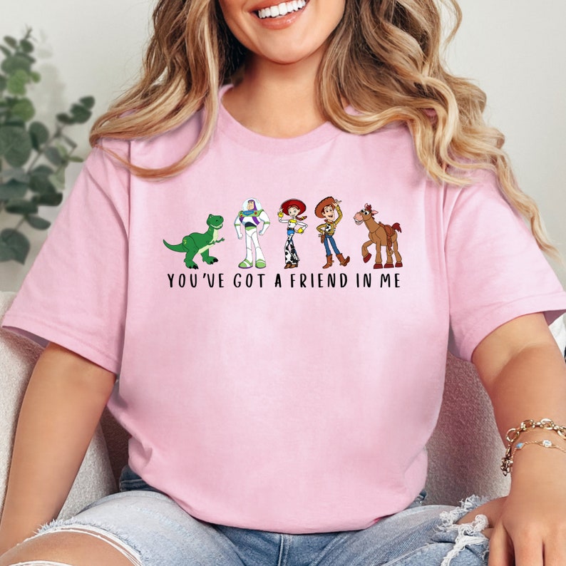 a woman wearing a pink t - shirt that says you've got a friend