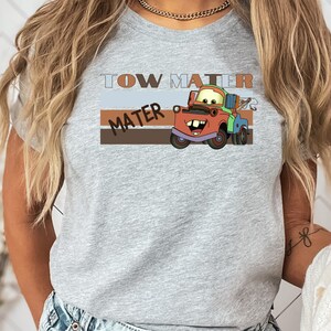 a woman wearing a tow truck t - shirt