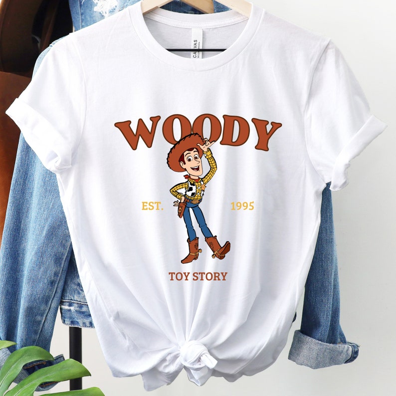 a white woody t - shirt hanging on a clothes rack
