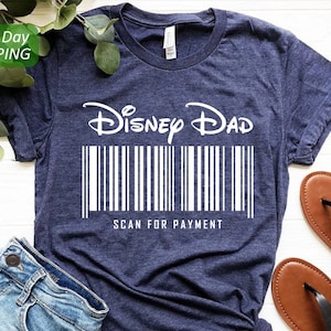 May include: A navy blue t-shirt with the text "Disney Dad" in white, with a barcode underneath and the text "Scan for Payment".