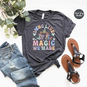 May include: A dark gray heather t-shirt with the text "Long Live All the Magic We Made" in rainbow colors. The text is surrounded by a cartoon castle and Mickey Mouse ears.