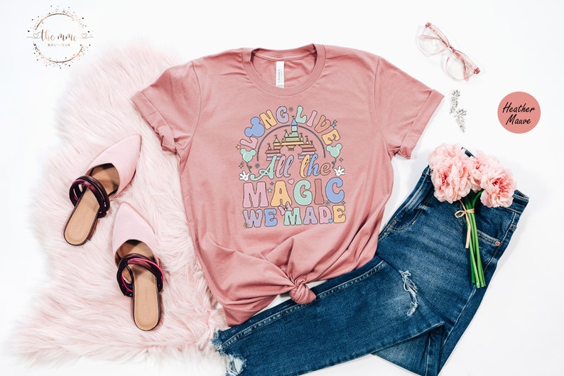 May include: A heather mauve t-shirt with a graphic design that says "Long Live All the Magic We Made" with a cartoon image of Cinderella's castle.