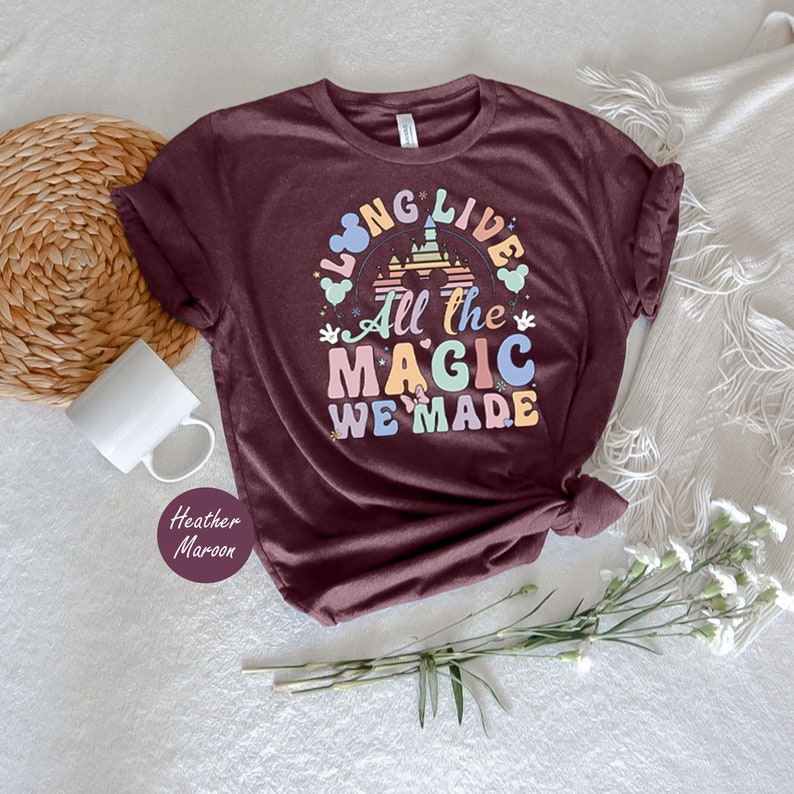 May include: A maroon t-shirt with the text "Long Live All the Magic We Made" in rainbow colors. The text is surrounded by a cartoon castle and Mickey Mouse ears.