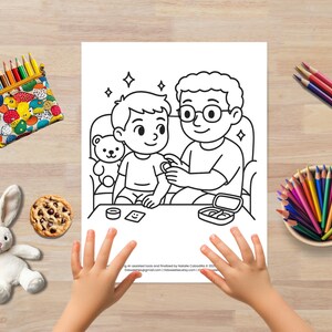Puede incluir: Una p&aacute;gina para colorear en blanco y negro que representa a un hombre ayudando a un ni&ntilde;o a ponerse un vendaje. El hombre lleva gafas y el ni&ntilde;o sostiene un oso de peluche. La escena est&aacute; ambientada en una sala de estar con un sof&aacute; y una mesa.