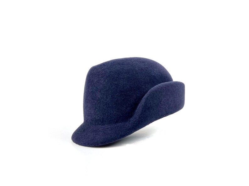 angle view of the navy sculpted velour hat, showing the short brim and sweeping side ear flap