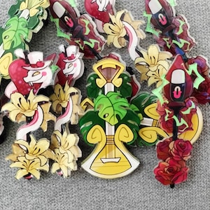 Op de afbeelding: Een verzameling kleurrijke emaille-pins met verschillende ontwerpen, waaronder een gitaar, bloemen en een schedel. De pins zijn allemaal in verschillende maten en vormen en perfect om elke outfit een vleugje persoonlijkheid te geven.