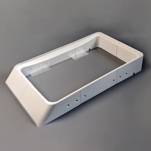 May include: White plastic frame with rounded edges and multiple small holes. The frame is designed to hold a rectangular object.