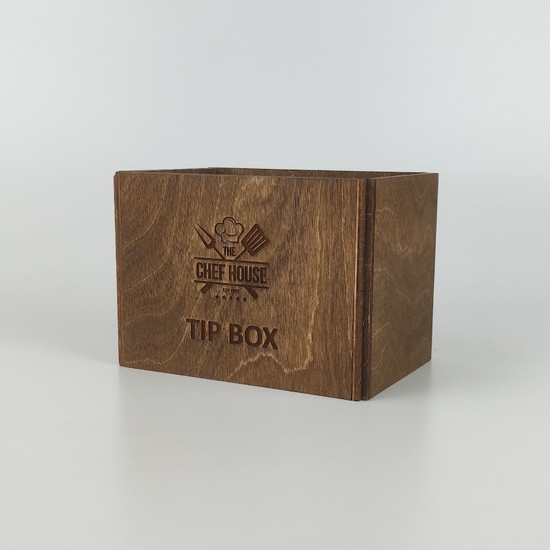 May include: A brown wooden tip box with the text "The Chef House" and "Tip Box" engraved on the front.