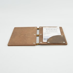 May include: A wooden receipt holder with a brown leather pocket and a white paper receipt that says "Cafe Restaurant Receipt".