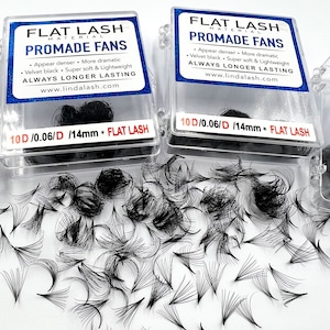 May include: Two clear plastic containers with black lash extensions. The containers are labelled "FLAT LASH MATERIAL PROMADE FANS" and include the text "10D/0.06/D/14mm + FLAT LASH".