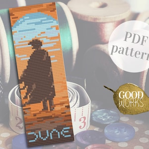 Op de afbeelding: Een PDF-patroon voor een kralen-bladwijzer met een silhouet van een persoon in een woestijnlandschap met het woord "DUNE" onderaan. Het patroon is van Good Works.