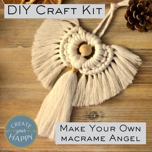 May include: DIY craft kit to make your own macrame angel. The kit includes white macrame cord, a wooden bead, and gold trim. The finished angel is white with a round centre and two long tassels.