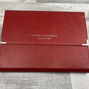 Red cabrini board-supported document wallet front cover with square nickel corners and silver foil personalisation in the centre of the wallet.